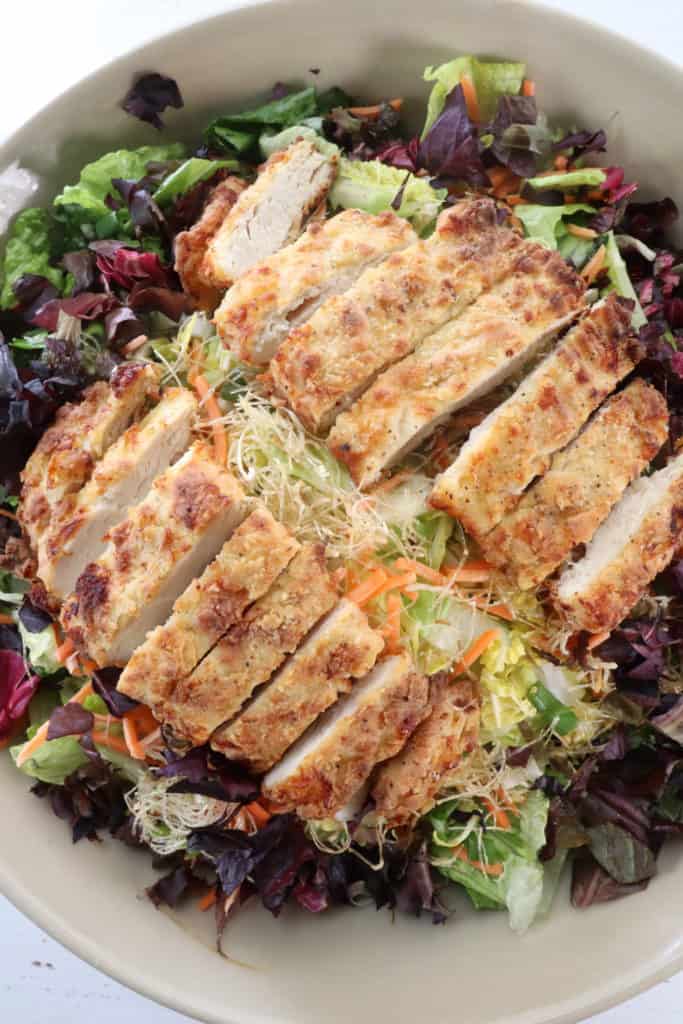 To Serve, add the sliced chicken breast on top of the salad, and drizzle with the salad dressing.