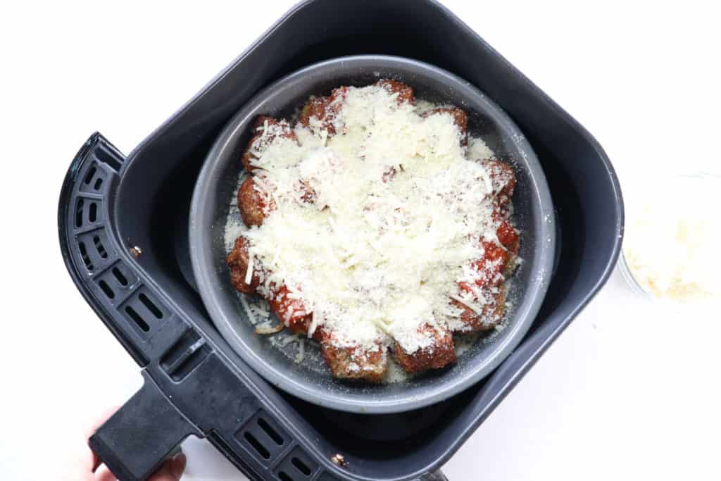 Spread the Marinara sauce over the cooked meatballs, and then sprinkle the mozzarella cheese on top. Set back into the air fryer for a couple of minutes at 350 degrees F or until the cheese has melted.