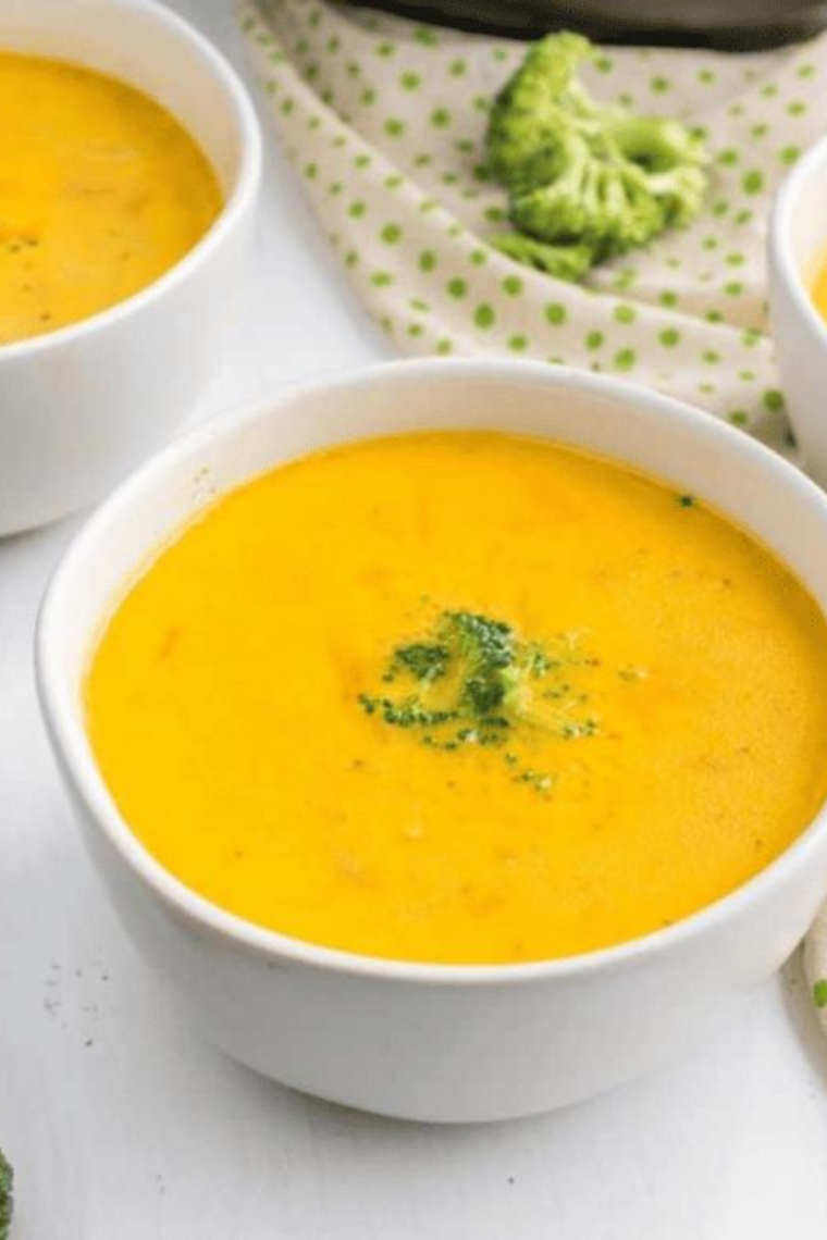 "Close-up of a bowl of Broccoli Cheese Soup, showcasing the smooth, cheesy texture and tender broccoli florets."