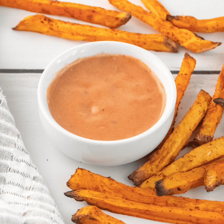 Golden, crispy Outback Steakhouse Sweet Potato Fries with seasoning, served with dipping sauce for a perfect homemade treat.