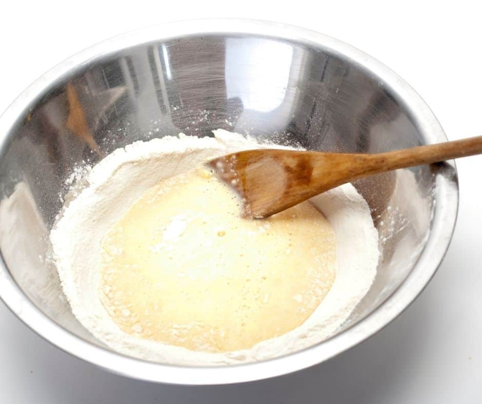 stirring pancake batter in a silver bowl