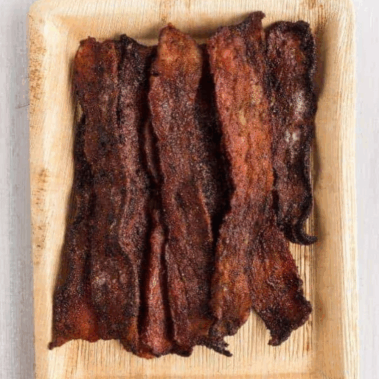 Crispy, smoky Air Fryer Bacon Jerky, seasoned with a blend of spices, perfect for a savory snack.