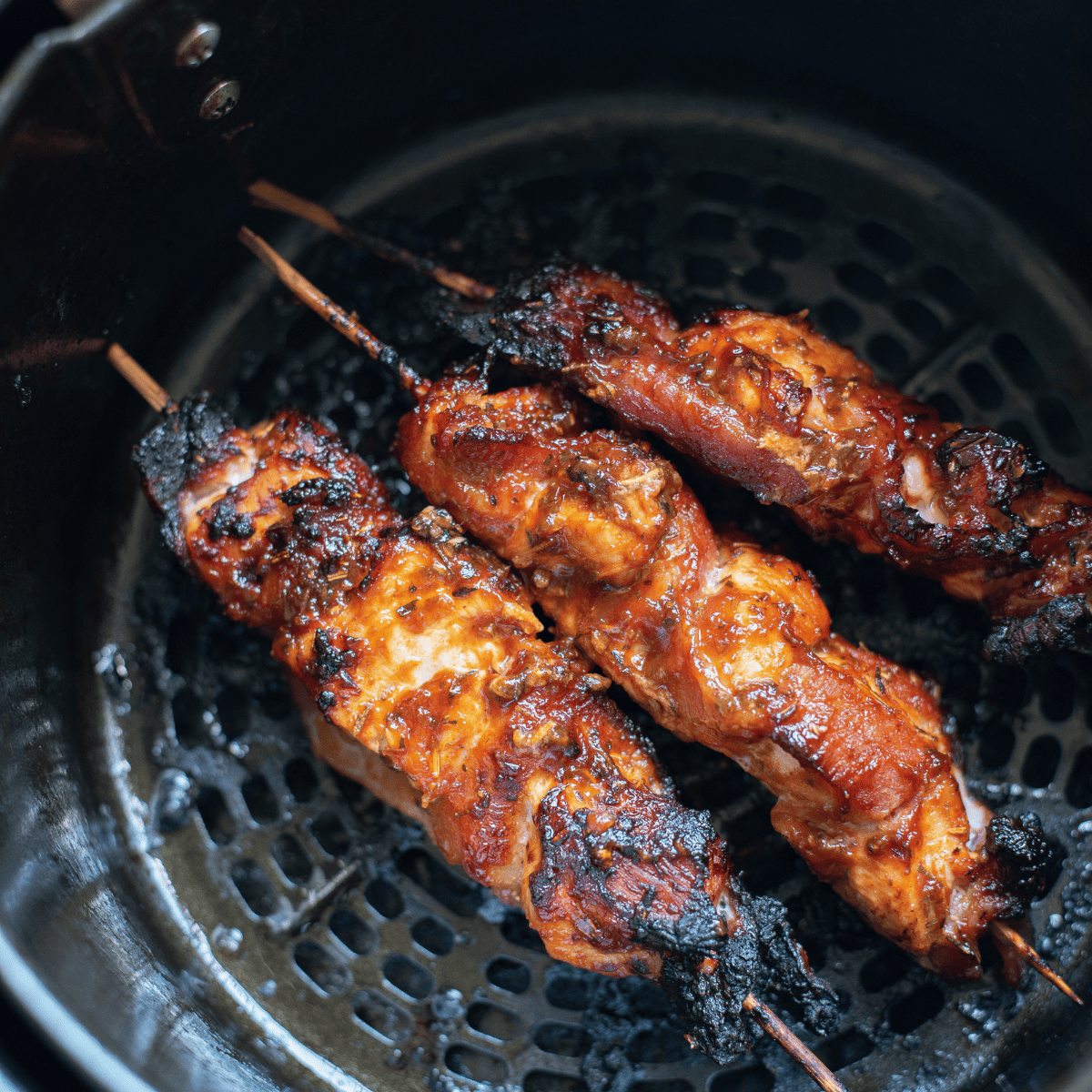 Pro Tips Here are some pro tips to ensure your Air Fryer Barbecue Bacon Wrapped Chicken Bites turn out perfectly every time: Choose the Right Bacon: Opt for thin to medium-thick bacon. Thick-cut bacon can take longer to crisp up and might not cook evenly with the chicken. Uniform Chicken Pieces: Cut the chicken into even-sized bite-sized pieces. This ensures that they all cook at the same rate and are done simultaneously. Prevent Stickiness: Lightly spray your air fryer basket with cooking spray or parchment paper with holes. This will help prevent the chicken bites from sticking to the basket. Secure the Bacon: Use toothpicks to secure the bacon around the chicken pieces. This prevents the bacon from unraveling during cooking. Avoid Overcrowding: Cook in batches if necessary. Overcrowding the air fryer can lead to uneven cooking and less crispy results. Brushing the Sauce: Apply the barbecue sauce before cooking for a deeper flavor infusion. You can also brush a little extra sauce on the bites halfway through cooking for a more glazed effect. Flipping is Key: Flip the chicken bites halfway through the cooking process. This ensures that the bacon gets crispy on all sides. Check Internal Temperature: Ensure the chicken is fully cooked by ensuring its internal temperature reaches 165°F (74°C). Rest Before Serving: Let the chicken bites rest for a few minutes after cooking. This helps redistribute the juices inside the chicken, making it more tender and flavorful. Sauce Variations: Experiment with different types of BBQ sauce, or mix in some honey, mustard, or hot sauce to customize the flavor to your liking. Garnish for Presentation: A sprinkle of fresh chopped parsley or chives can add color and a fresh flavor contrast. Serving Suggestions: Serve with dips like ranch dressing, blue cheese, or more BBQ sauce on the side for added flavor. Cleanup Tip: If you find the sauce has left a sticky residue in your air fryer, soaking the basket in warm, soapy water for a while will make cleaning easier. Following these tips will help you create a delicious and visually appealing dish that's sure to be a hit with family and friends! Faq's What type of chicken is best to use for this recipe? Boneless, skinless chicken breasts are typically used for their lean nature and even cooking. You can also use chicken thighs for a juicier option. Can I use thick-cut bacon for this recipe? It’s best to use thin to medium-thick bacon as it wraps easily and cooks evenly with the chicken. Thick-cut bacon may not cook through properly and can leave the chicken overcooked. How do I prevent the chicken bites from sticking to the air fryer? Lightly spray the air fryer basket with cooking oil or use a perforated parchment liner designed for air fryers to prevent sticking. How long should I cook the chicken bites in the air fryer? Typically, it takes about 10-15 minutes at 390°F (200°C), depending on your air fryer model. It's important to flip them halfway through for even cooking. How do I know when the chicken is done? The internal temperature of chicken should have an internal temperature of 165°F (74°C). A meat thermometer is handy for checking this. The size of the chicken will determine the cooking time. Can I prepare these chicken bites ahead of time? Yes, you can wrap the chicken in bacon and refrigerate them for a few hours before cooking. Just brush them with BBQ sauce right before air frying. What are some good dipping sauces for these chicken bites? Ranch dressing, blue cheese sauce, honey mustard, or extra barbecue sauce are great options. Can I make this recipe gluten-free? Yes, just ensure that the barbecue sauce and any other added ingredients are gluten-free. How should I store leftovers? Store any leftovers in an airtight container in the refrigerator for up to 3 days. Reheat in the air fryer for best results. Can I freeze the cooked chicken bites?Yes, once cooled, you can freeze them in a sealed container or freezer bag. Reheat in the air fryer straight from frozen, adjusting the cooking time as needed. Are these chicken bites keto-friendly? They can be, depending on the barbecue sauce used. Opt for a low-sugar, keto-friendly BBQ sauce to make this dish suitable for a ketogenic diet. Can I make these bites in an oven if I don't have an air fryer? Yes, you can bake them in an oven preheated to 400°F (205°C) for about 20-25 minutes, or until the bacon is crispy and the chicken is cooked through. More Air Fryer Recipes