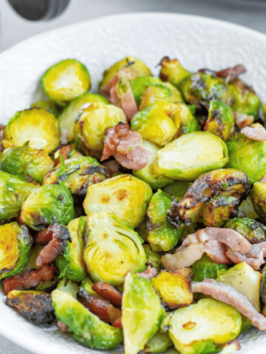 Bowl of crispy air fryer Brussels sprouts with chopped bacon and a honey-garlic glaze