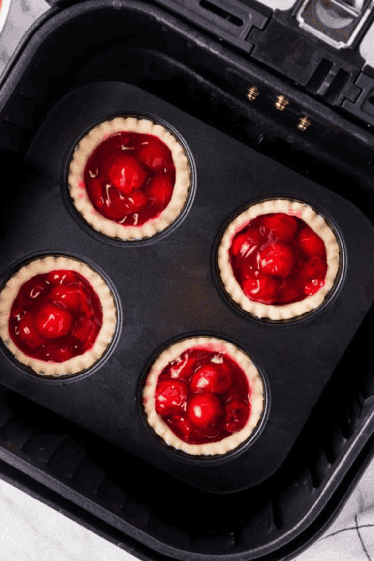 Tarts in the air fryer set to 320°F for 5-7 minutes, baking to golden perfection.