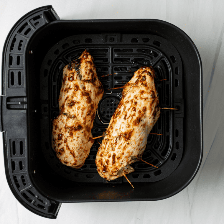 Breaded chicken rolls cooking in air fryer until golden and crispy