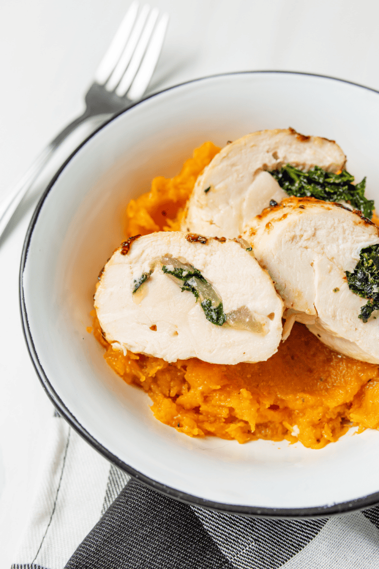 Crispy air fryer Chicken Kiev sliced open showing melted garlic herb butter oozing from the center of juicy chicken breast.