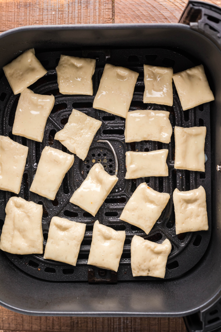 Puff pastry squares arranged in air fryer basket cooking until golden, puffed, and crispy at 400&deg;F