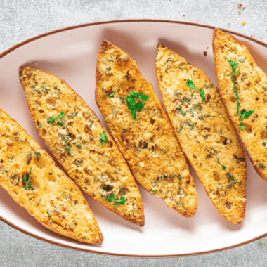 Air fryer garlic bread with fresh herbs, real butter, and parmesan. Crispy outside, soft inside, ready in under 10 minutes &mdash; no preheating needed.