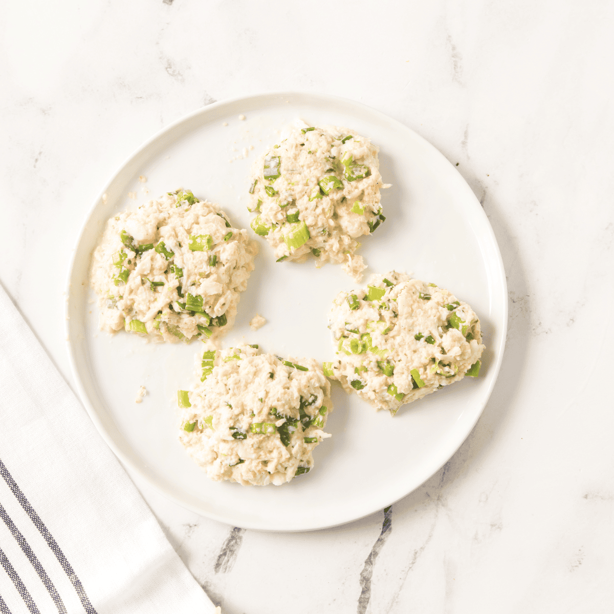 Shaped crab cakes on white plate.