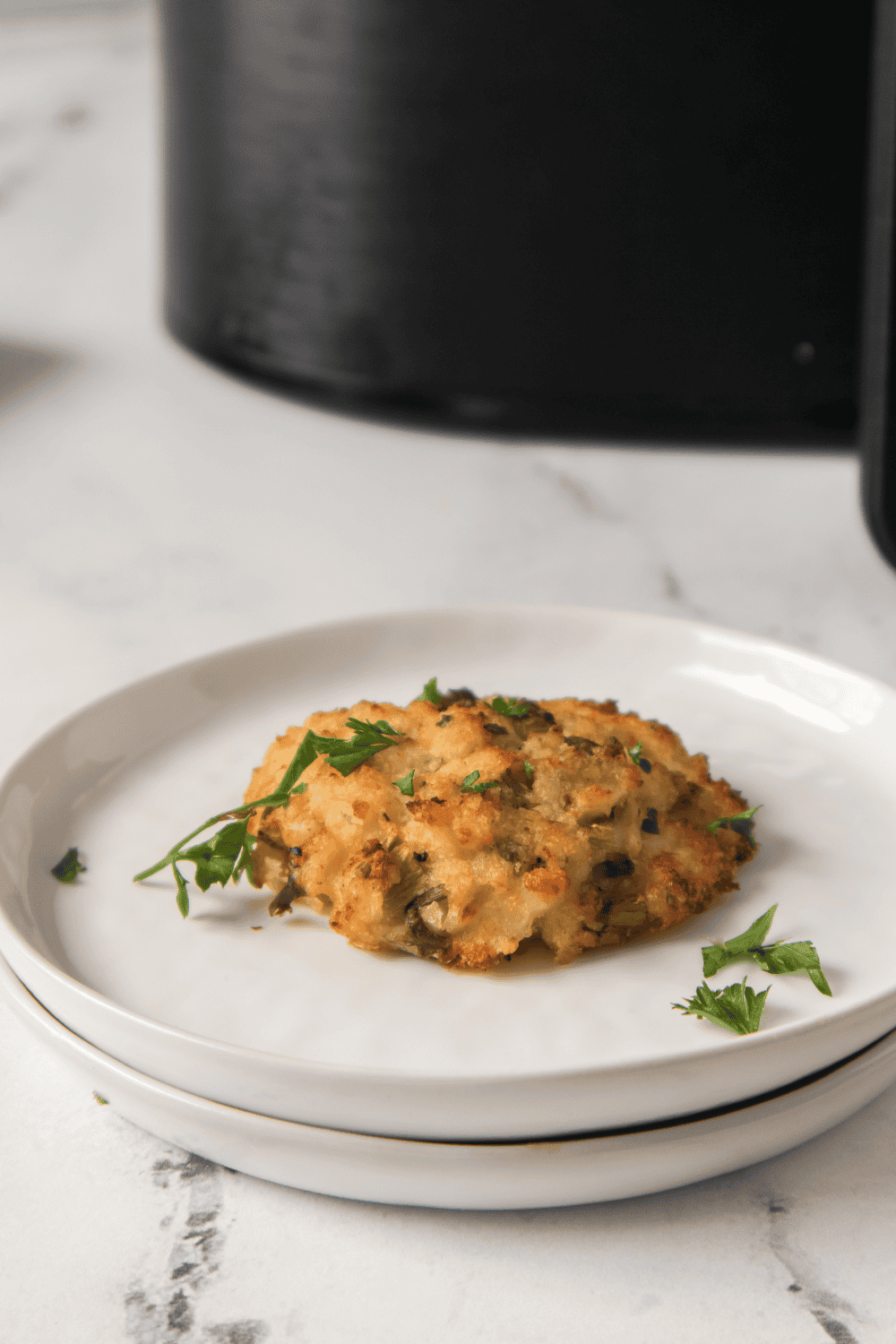 Plate of Air Fryer Lemon Crab Cakes, with fresh herbs on top.