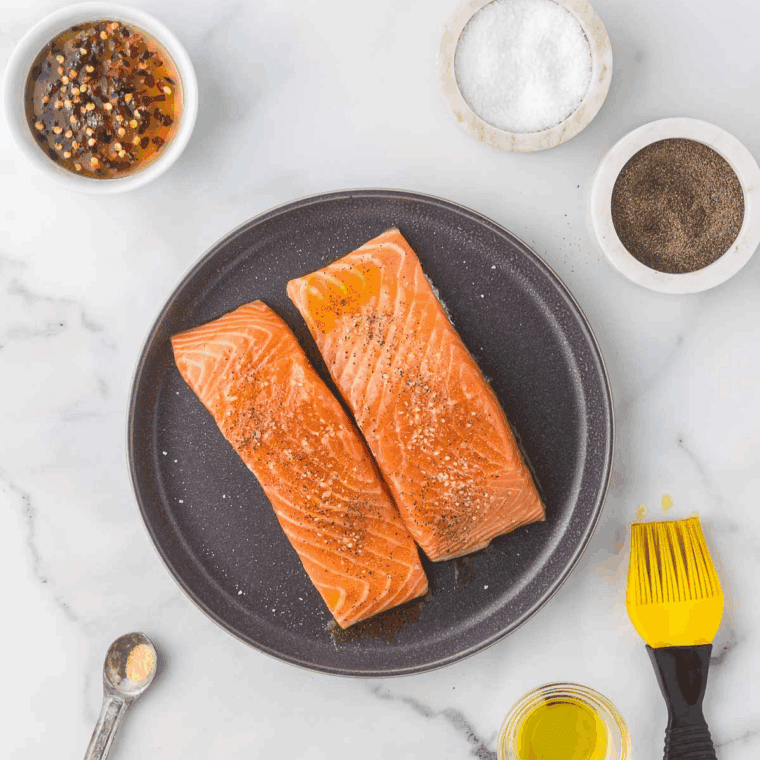 Salmon fillets brushed evenly with maple glaze, ready for cooking