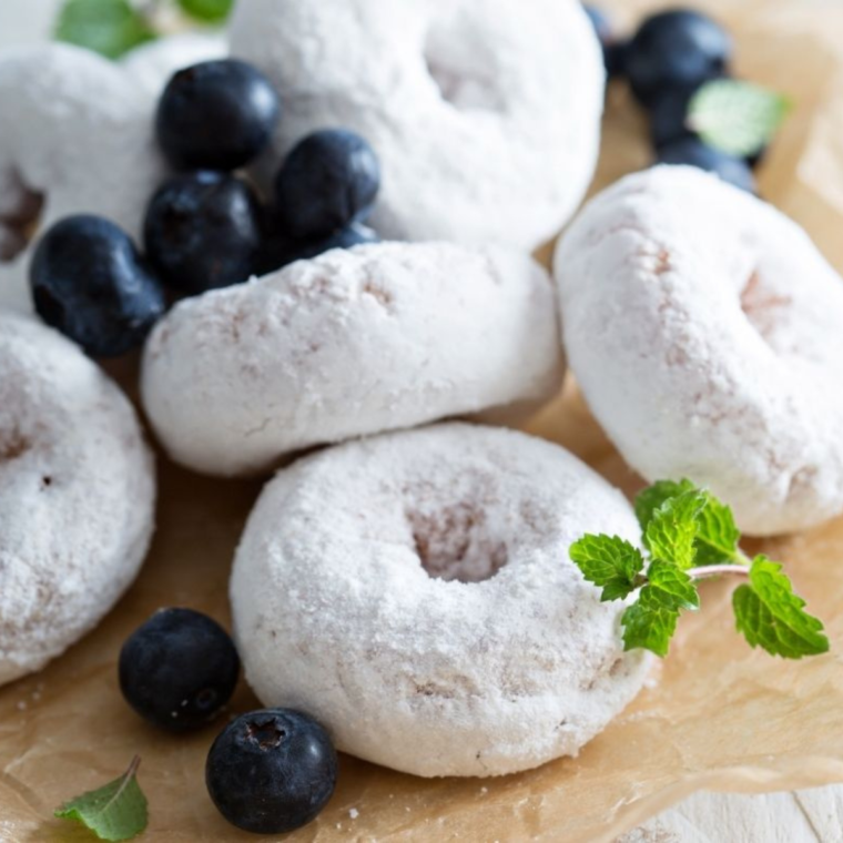 "Fluffy Air Fryer Donuts topped with a generous sprinkle of powdered sugar."