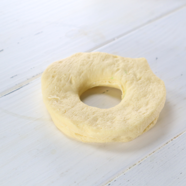 Biscuit dough on cutting board with a hole in the center.