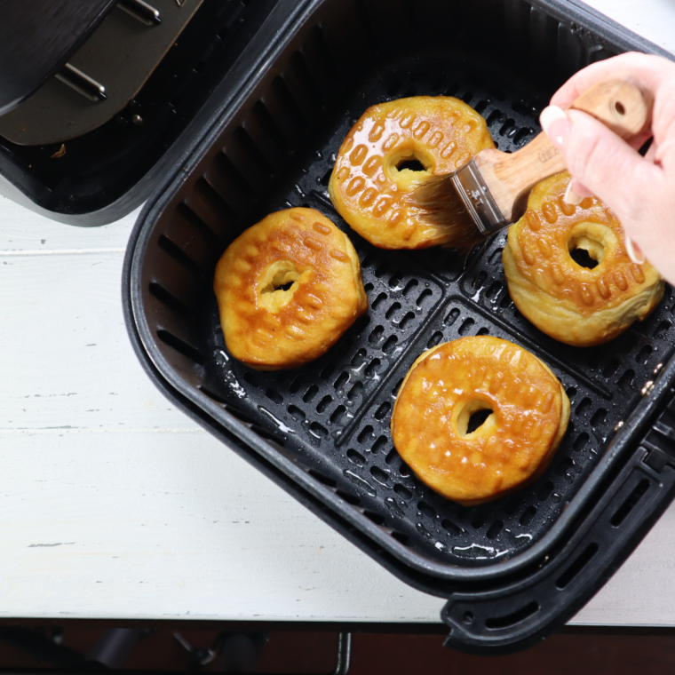 Brush melted butter over the donuts.