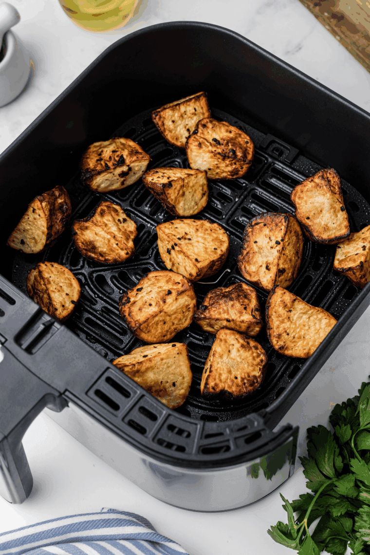 Air fryer red potatoes coated in olive oil, garlic, and seasoning, golden brown and crispy, ready to serve.