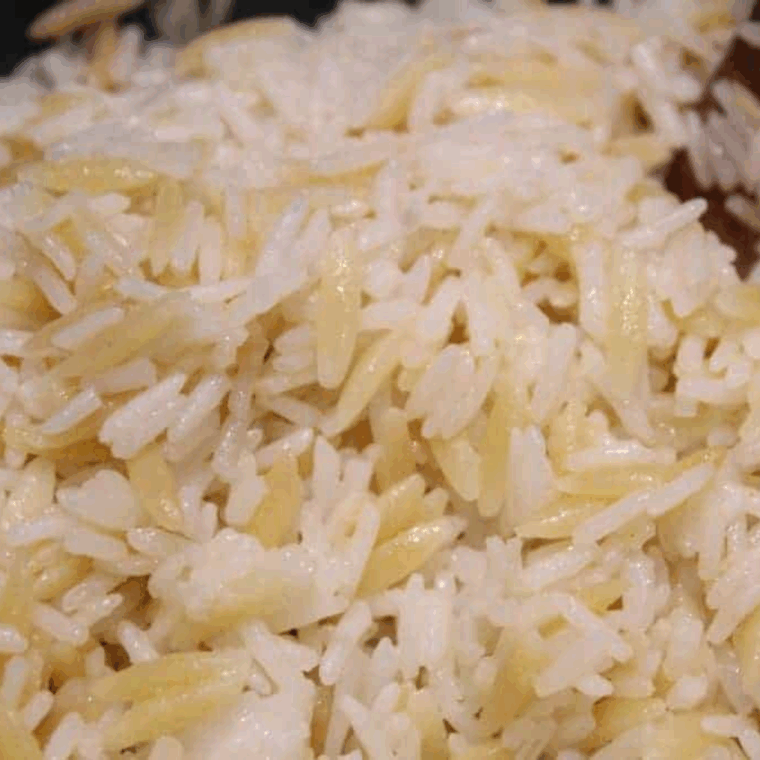 Bowl of Applebee’s Almond Rice Pilaf with toasted almonds and parsley garnish.