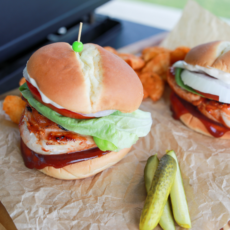 Juicy BBQ chicken burger cooking on a Blackstone griddle with smoky barbecue glaze.