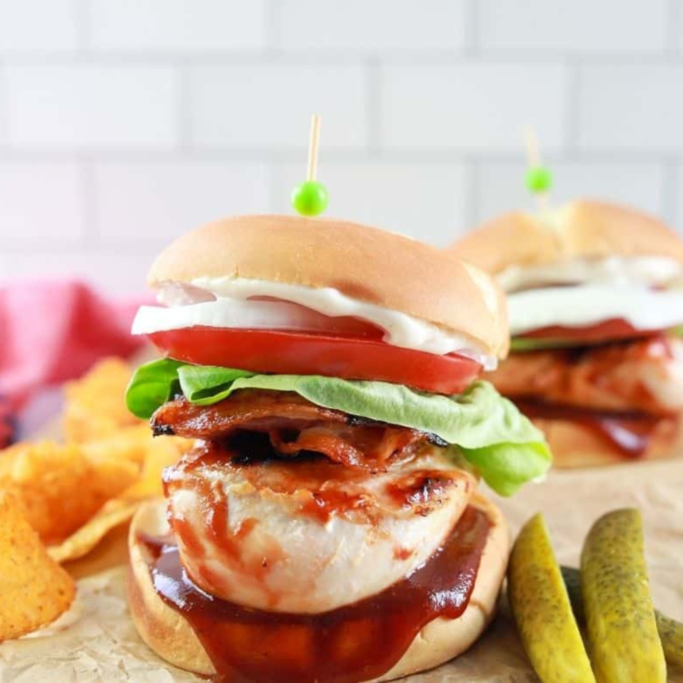 Copycat Carl's Jr. BBQ Chicken Sandwich with grilled chicken, barbecue sauce, lettuce, tomato, cheddar cheese, and crispy onion rings.