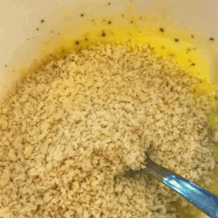 Panko breadcrumb topping mixed with butter, garlic, shallots, and herbs in a bowl.