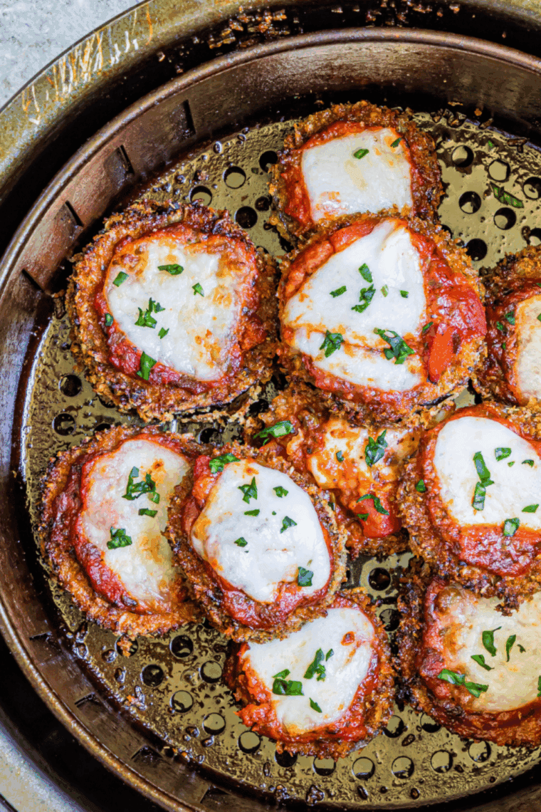 Crispy, golden-breaded eggplant layered with marinara sauce and melted cheese, served on a plate, Cheesecake Factory style.