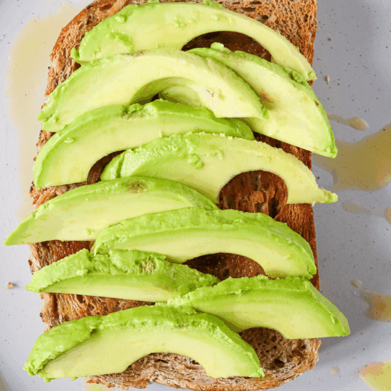 Sliced avocado placed on the toast.