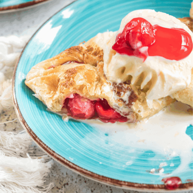 Golden homemade cherry turnovers with sweet cherry filling and icing drizzle