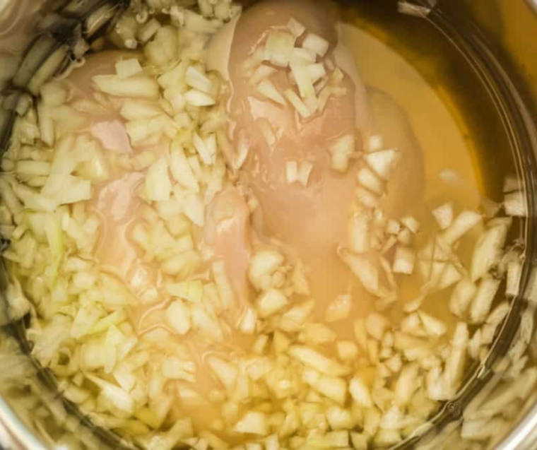 "Sautéing vegetables in the Instant Pot for Chicken Pot Pie Soup, showing onions, carrots, and celery in the pot."