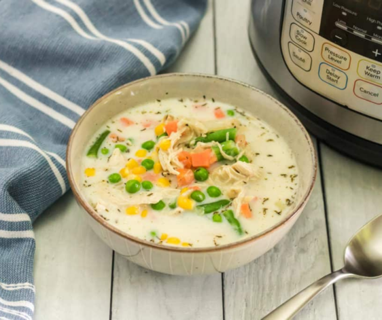 "Finished Chicken Pot Pie Soup being ladled into bowls from the Instant Pot, showcasing the creamy texture and hearty ingredients."