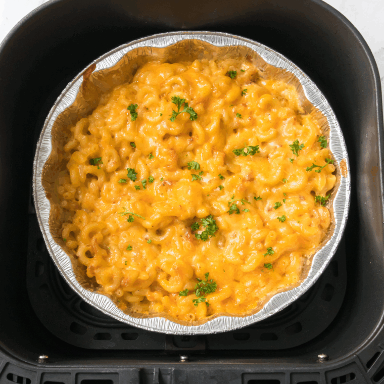 Bowl of creamy homemade Outback Steakhouse Mac and Cheese garnished with melted cheddar and parsley.