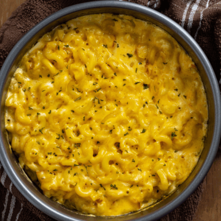 Bowl of creamy Outback Steakhouse mac and cheese topped with melted cheddar.