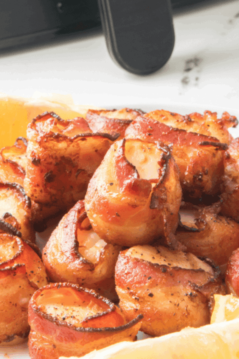 Close-up of homemade Red Lobster bacon wrapped scallops served on a white plate with fresh herbs.