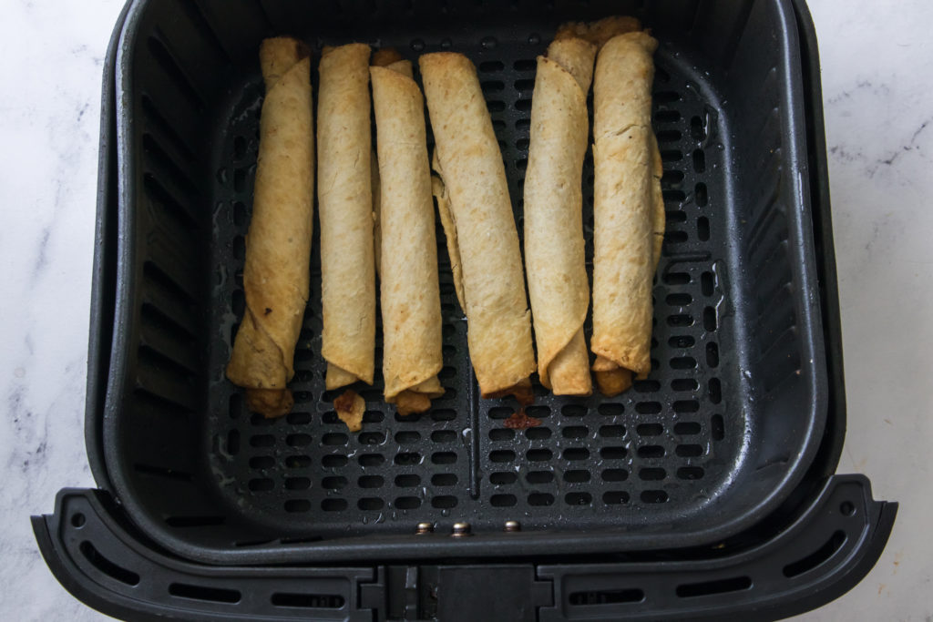 Preheat the Air Fryer:

Preheat your air fryer to 400 degrees F (190°C) for 1-2 minutes. Preheating ensures even cooking and a crispy texture.

Lightly Coat with Cooking Spray (Optional):

While this step is optional, lightly spraying the taquitos with cooking spray can help them become even crispier. You can skip this step if you prefer.

Arrange in the Air Fryer:

Place taquitos in a single layer in the air fryer basket or on the air fryer tray. Avoid overcrowding to allow proper air circulation. If your air fryer is small, you may need to cook them in batches.

Air Fry the Taquitos:

Set the cooking temperature to 400 degrees Fahrenheit, and the cooking time for 8-10 minutes, shaking the basket or flipping them halfway through the cooking process to ensure even browning.

Optional Toppings:

If you'd like to add shredded cheese, sprinkle it on the taquitos during the last 2 minutes of cooking. This allows the cheese to melt and become gooey.

Check for Crispy Perfection:

The taquitos are done when they are golden brown and crispy. Keep an eye on them during the last few minutes to avoid overcooking.

Serving

Remove the taquitos from the air fryer and let them cool for a minute or two. They are best enjoyed while still hot and crispy. Garnish the taquitos with fresh cilantro, lime wedges, avocado, jalapeño, or other toppings of your choice for added flavor and presentation. Season the taquitos with a pinch of salt and freshly ground black pepper to taste! Serve your hot and crispy air fryer frozen taquitos with your favorite dipping sauces or toppings for a delicious and convenient snack or meal.