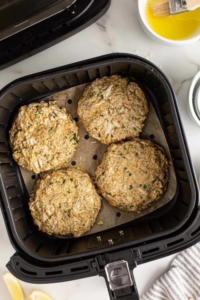 Golden brown air-fried crab cakes ready to be served on a plate.