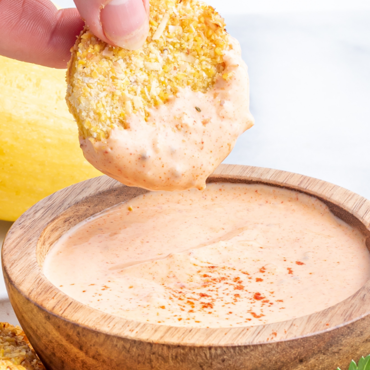 Air fryer fried squash served with a small bowl of dipping sauce