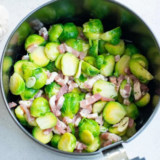Frozen Brussels sprouts and chopped bacon cooking together in an air fryer basket
