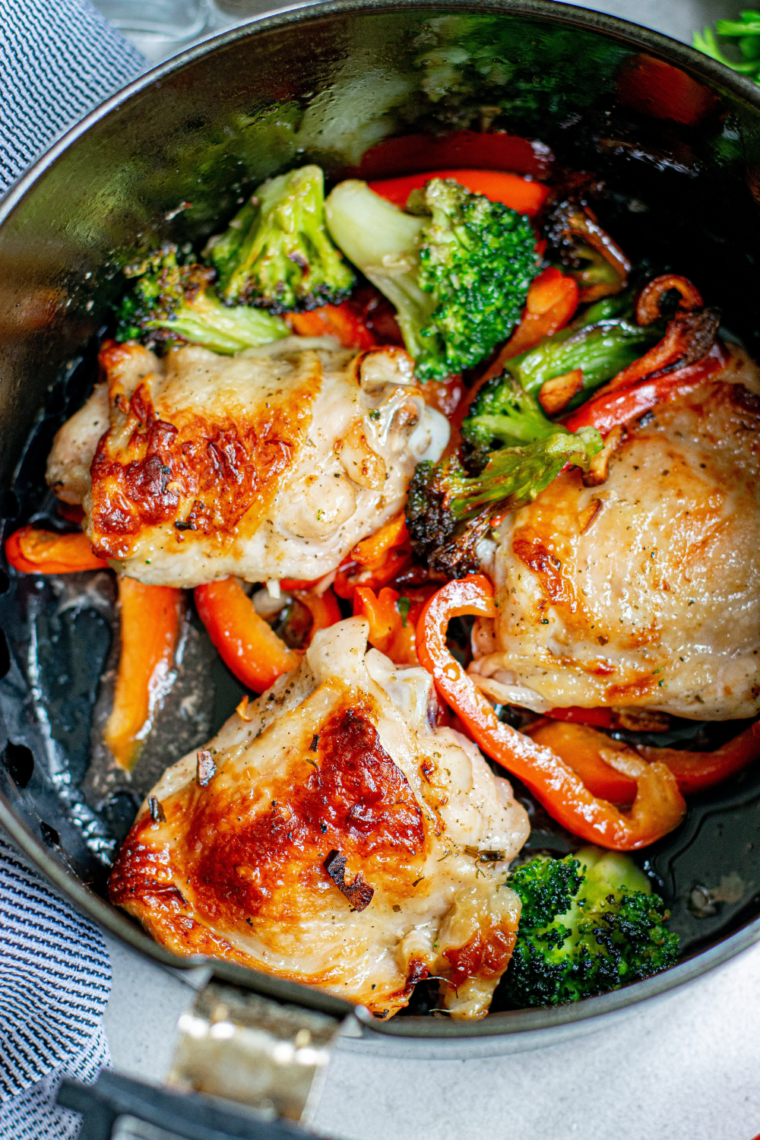 Marinated chicken thighs placed in air fryer basket, cooking to perfection.