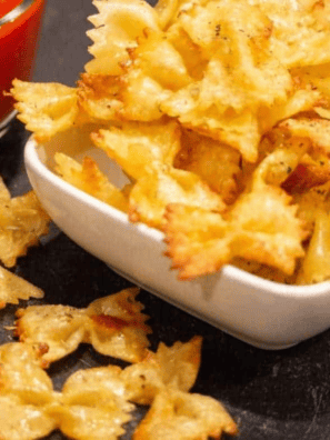 Bowl of crispy air fryer pasta chips served with marinara dipping sauce