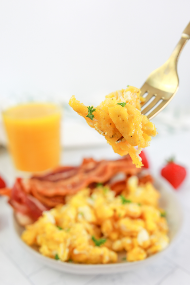 scrambled eggs cooking in air fryer basket creamy and soft curds