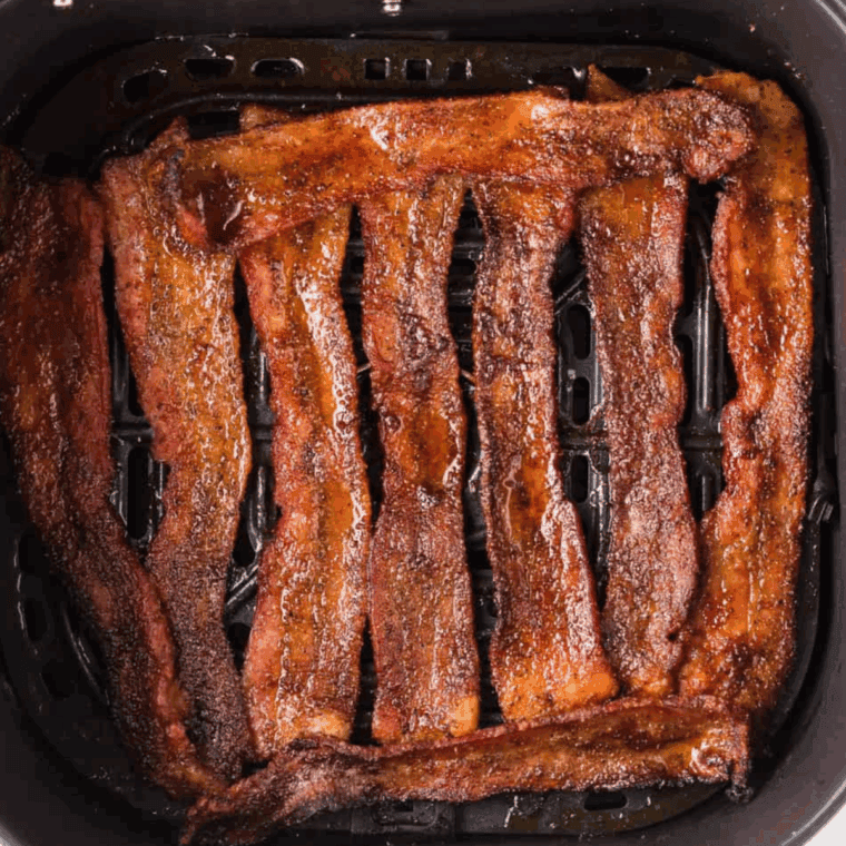 Cooked bacon in the air fryer basket.
