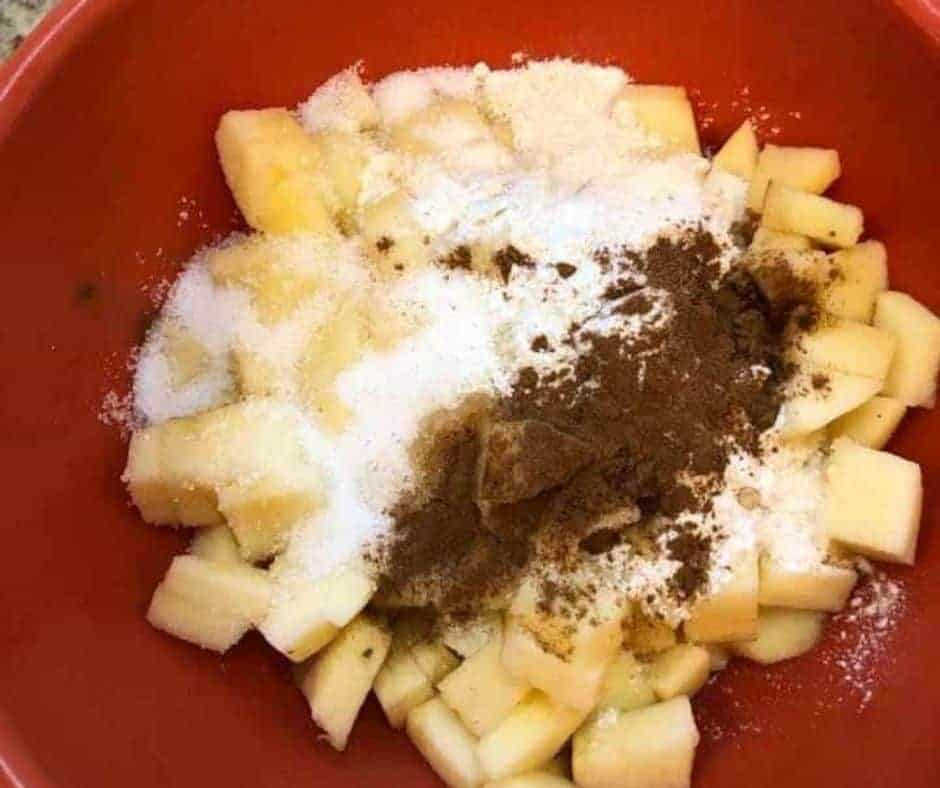 Make the pie filling, in the bowl, add the diced apples, flour, sugar, ground cinnamon, vanilla extract.