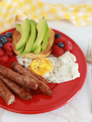 Plate of Ninja Crispi breakfast sausage links served with two fried eggs and fresh fruit
