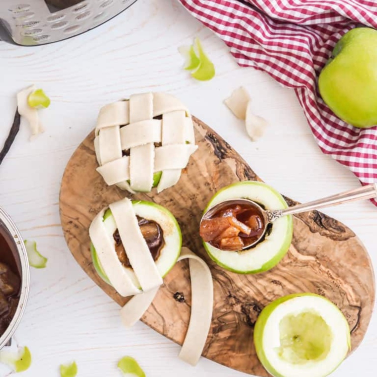 Topping filled apples with dough, weaving a lattice pattern, brushing with an egg/milk mixture, and sprinkling cinnamon sugar on top.