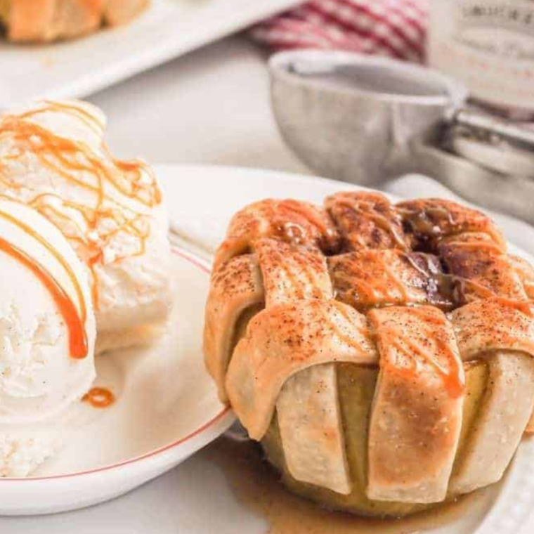 Air Fryer Apple Pie Baked Apples with a cinnamon-sugar filling, golden crust, and topped with caramel and vanilla ice cream.