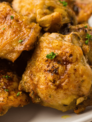 Alt Tag: Golden-brown air fryer chicken thighs cooked in a Ninja Crispi, served on a plate with fresh herbs.