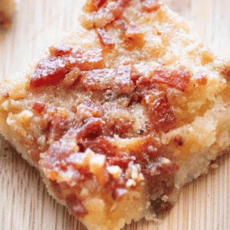 Air Fryer KETO Maple Bacon Crack on parchment paper topped with crispy bacon and sugar-free maple glaze