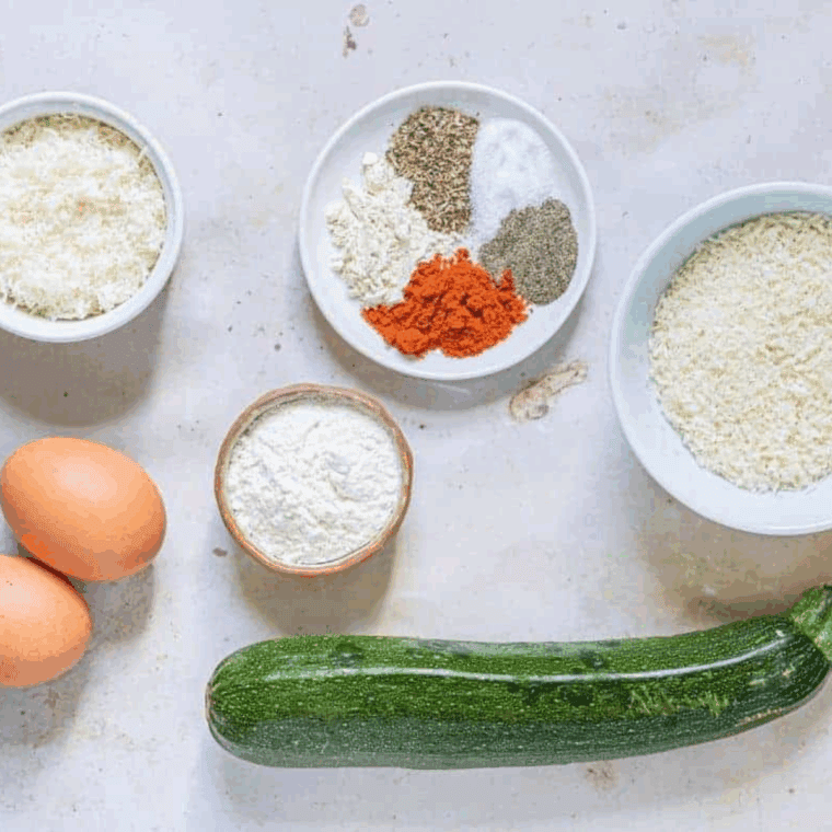 Ingredients needed for Air Fryer Parmesan Crusted Zucchini Crisps on kitchen table.