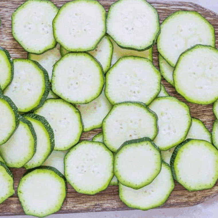 Sliced zucchini on a cutting board.