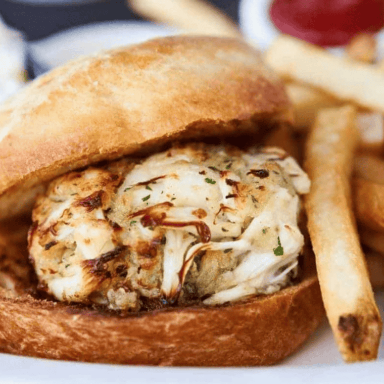 Crispy air fryer crab cake sandwich on brioche bun with lettuce, tomato, and remoulade sauce