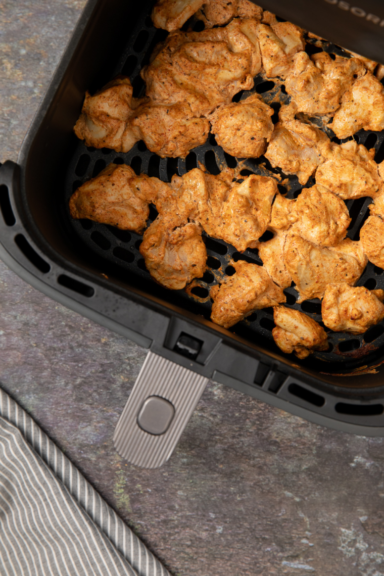 Sliced chicken served over rice with colorful vegetables, garnished with fresh herbs and a squeeze of lemon.